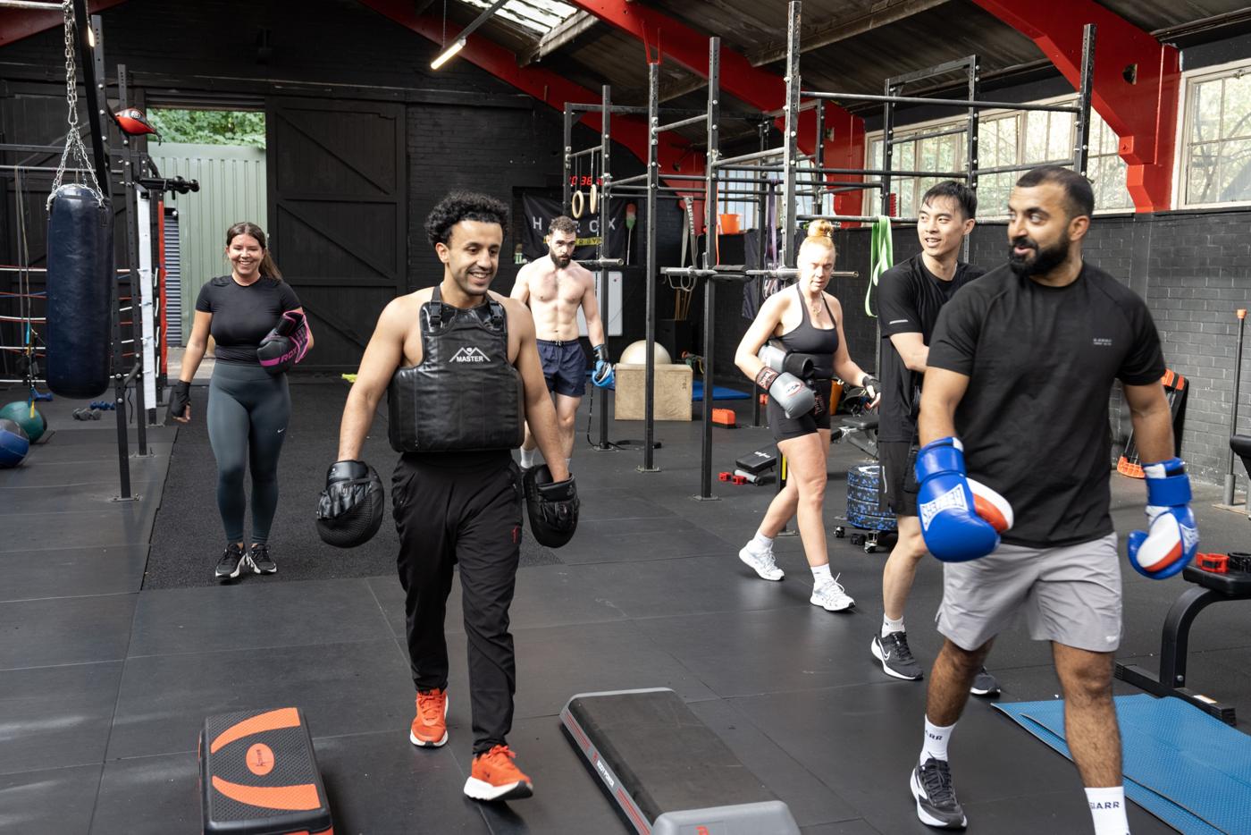 Members heading into a boxing class together, smiling